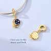 A gold-toned charm bracelet featuring a moon charm with stars and a separate charm that reads I love you to the moon and back