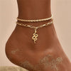 Gold chain anklet bracelet worn on a person's ankle with body glitter