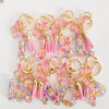 Alphabet letter acrylic keychains in various colors with pink butterfly tassels
