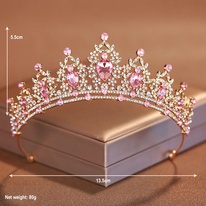 A delicate pink and clear crystal baroque bridal tiara headpiece displayed on a box.