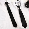 A black clip-on security tie is displayed against a white shirt.