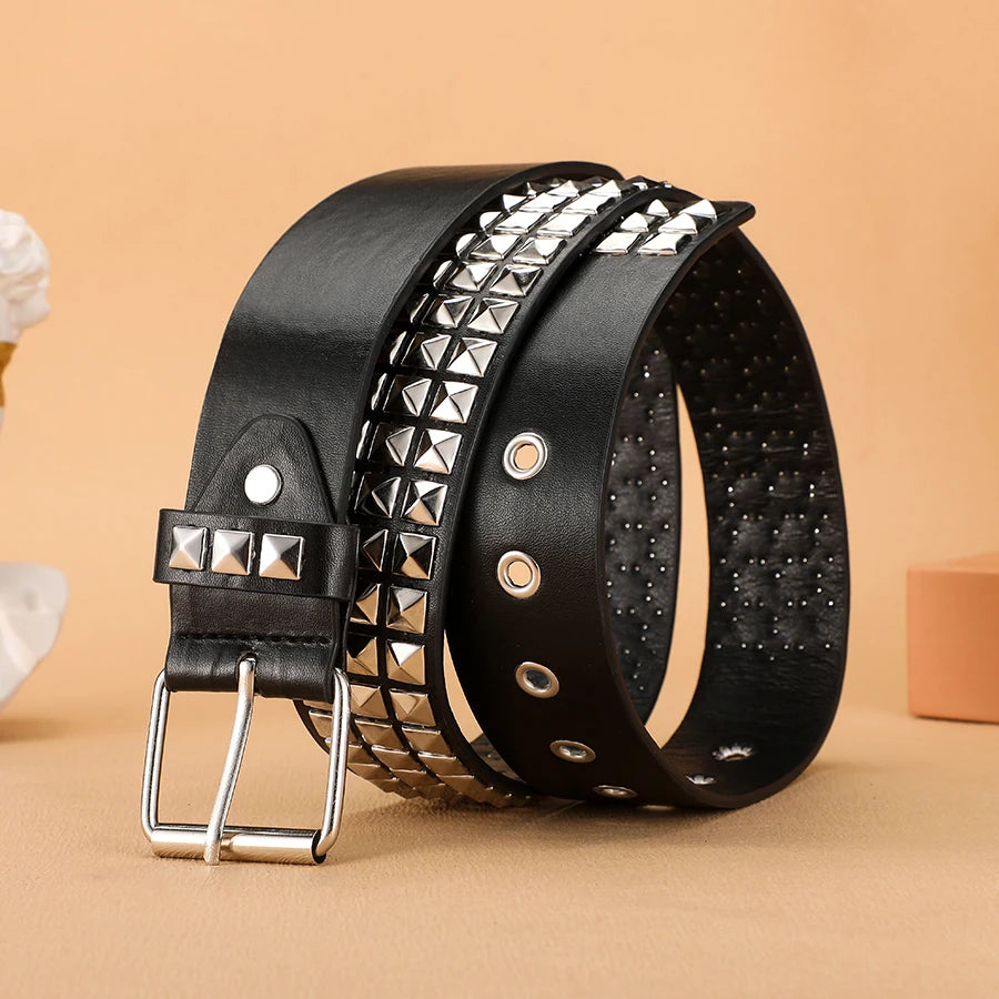 Black leather belt featuring silver rivets and studs, shown on a beige background.