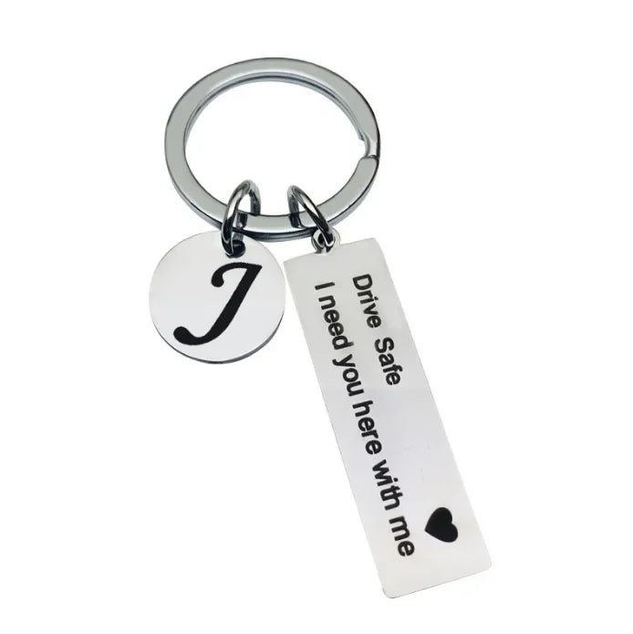 Silver keychain with a J charm and a tag that reads Drive Safe I need you here with me