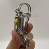 Un porte-clés mécanique en acier inoxydable avec une boucle et un mécanisme à ressort tenu dans une main.