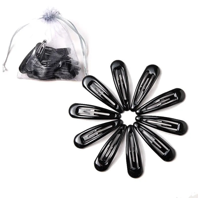 Una colección de pinzas para el cabello negras y brillantes dispuestas en un patrón circular sobre un fondo blanco.