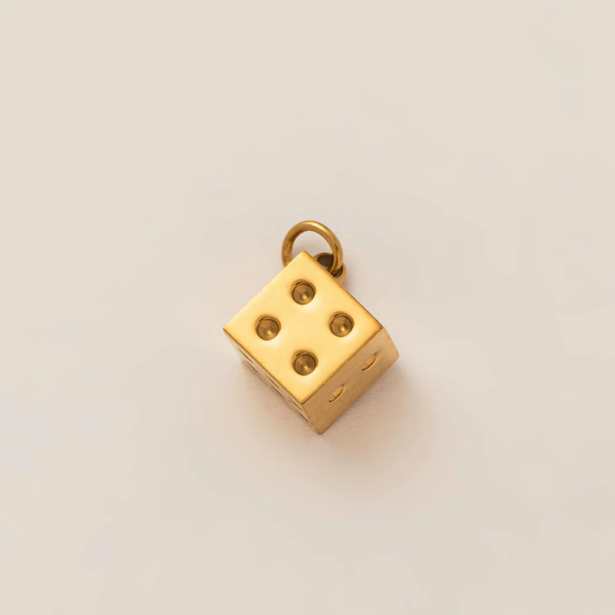 A gold plated butterfly key pendant charm resting on a neutral background.