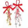 A red ribbon charm featuring a gold Saint Benedict medal and dangling charms.