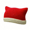 A bright red crocheted cat ears beanie hat with a cream-colored brim.