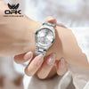 A close-up shot of a silver luminous quartz water resistant watch worn on a person's wrist.