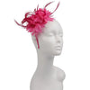 Un bandeau fascinateur en plumes magenta vibrant présenté sur un mannequin de tête blanc.