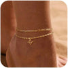 Gold layered letter anklet bracelet worn on a wrist.