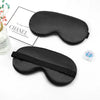 Black silk sleep mask with a strap shown next to a luxury bag brand logo