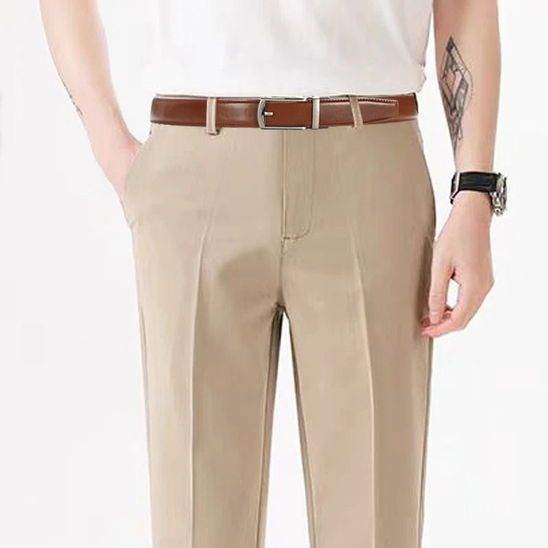 Un homme portant un pantalon beige et une ceinture en cuir marron à molette.