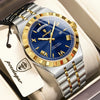 A silver and gold watch with a blue dial and gold accents is displayed in a box.