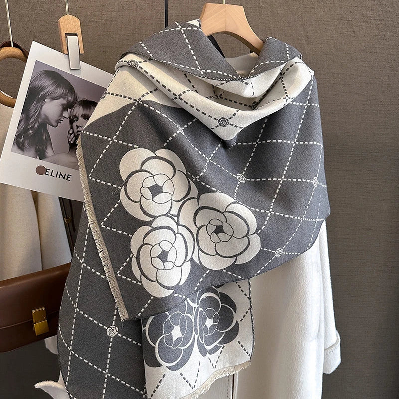 A gray and white plaid cashmere feel scarf draped over a hanger.