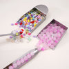 Stainless steel tool with a tray filled with colorful beads and a separate tray of pink beads for jewelry making