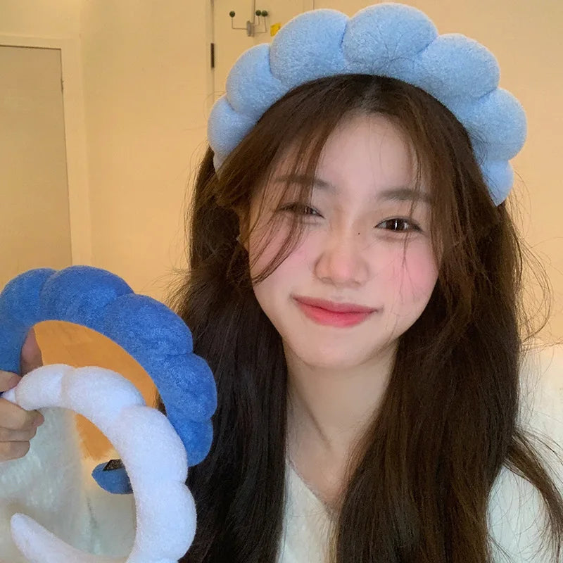 A young woman models blue cloud sponge hair accessories headbands and a white headband.