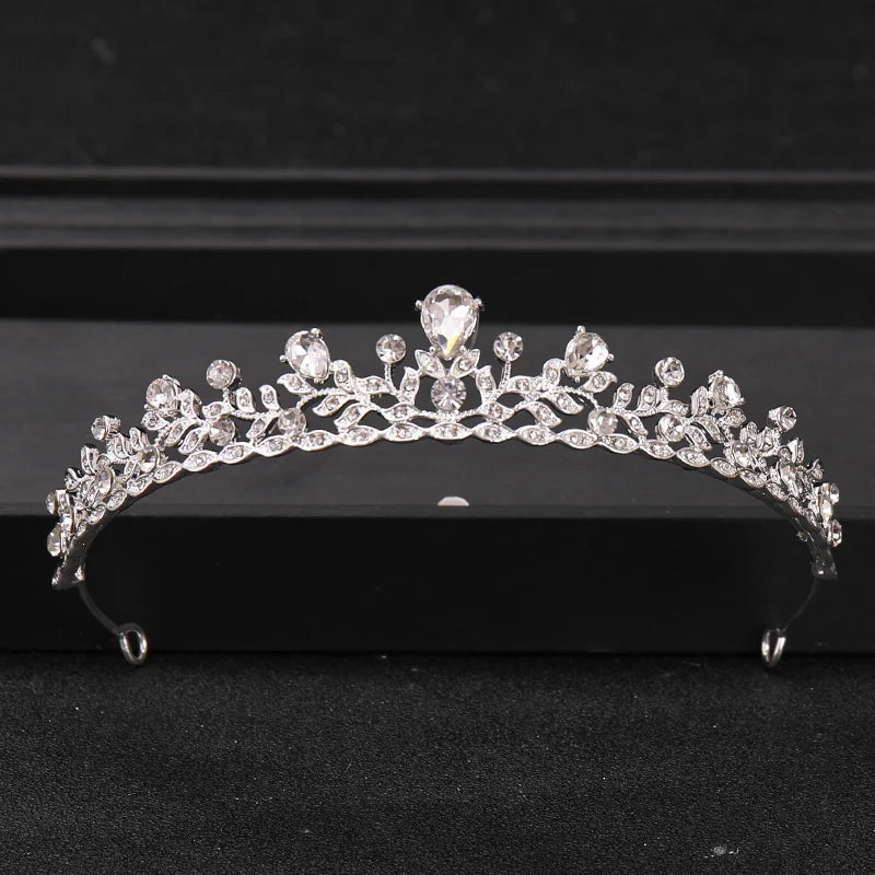 A sparkling crystal rhinestone bridal tiara headpiece displayed on a dark surface.