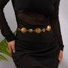Gold heart-shaped waist chain body jewelry worn on a black dress.