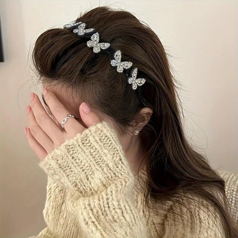 A woman shows off a black rhinestone butterfly hair accessory woven into her dark brown hair.