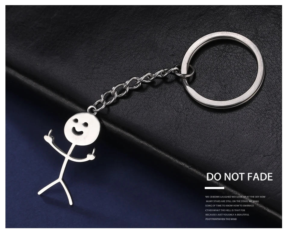 Silver chain keychain featuring a stickman making the middle finger gesture on a dark surface.