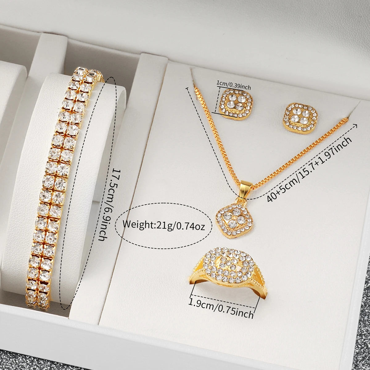 A set of gold-toned quartz jewelry including a necklace, earrings, and ring displayed in a white box.