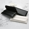 Black and white leather eyeglass cases resting on a white plate.