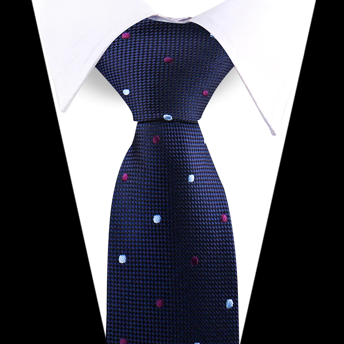 A dark blue patterned silk necktie with scattered pink and blue floral dots shown against a white shirt.