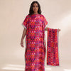 A woman models a vibrant pink and orange patterned long silk blend cover-up robe dress.