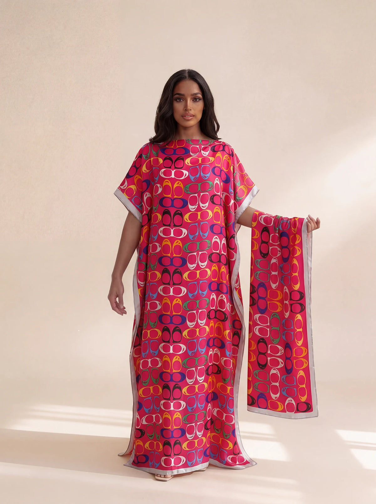 A woman models a vibrant pink and orange patterned long silk blend cover-up robe dress.