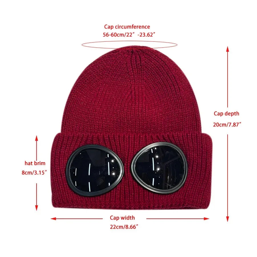 A maroon knit windproof hat with a ribbed cuff and round tinted lenses.
