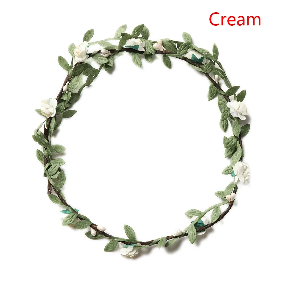 A green floral wreath headband made of leaves and small white flowers.