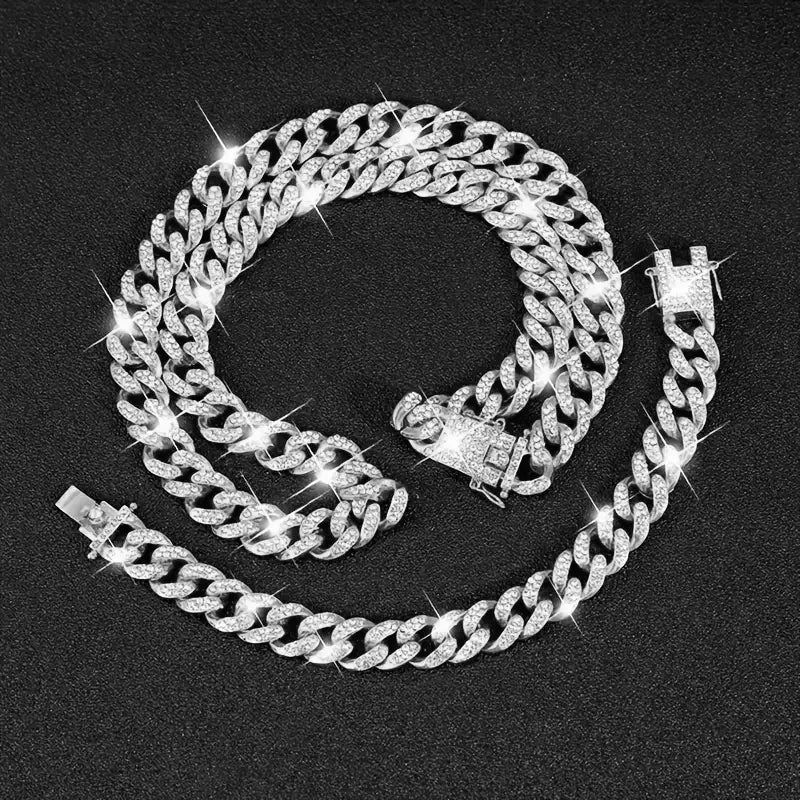 Un ensemble de trois colliers de chaîne cubains en argent exposés sur un fond sombre.