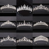 A collection of ornate silver and crystal bridal crowns displayed on a black velvet background.