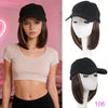 Una modelo vistiendo una gorra de béisbol sintética negra ajustable y una blusa rosa claro.