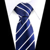 A dark blue silk necktie with diagonal white stripes worn under a white dress shirt.