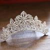 A sparkling crystal princess tiara hair comb for women displayed on a wooden surface.