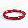 Una pila de cuentas rojas formando una pulsera flexible de cadena de cuentas.