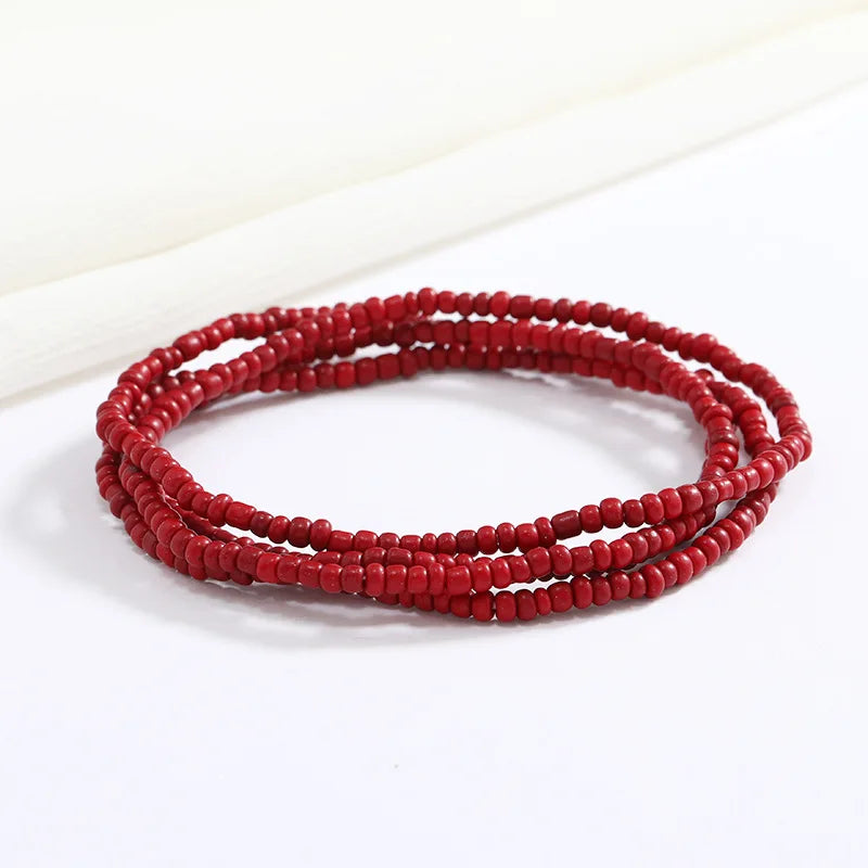 Una pila de cuentas rojas formando una pulsera flexible de cadena de cuentas.