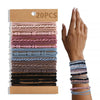 A hand holds a stack of various colored boho hair ties and headbands for ponytails.