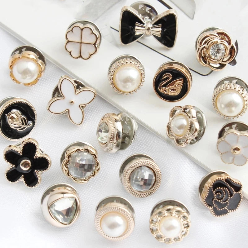 A collection of elegant button brooch pins featuring pearls, gold accents, and floral designs.