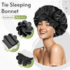 A woman wearing a black satin sleeping bonnet with an adjustable tie band.