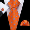 Orange silk jacquard tie featuring blue star patterns worn with a white dress shirt.