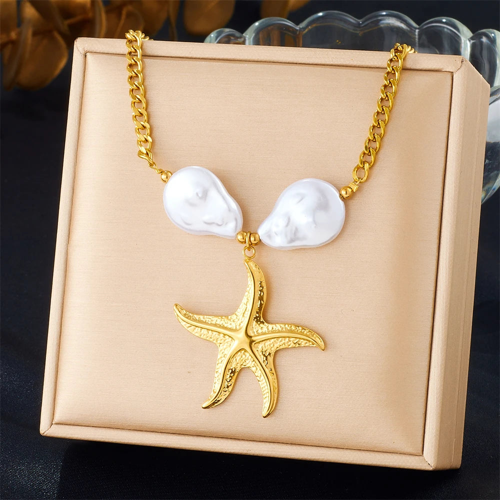 Gold chain necklace with white heart pendants and a starfish charm presented in a light brown box