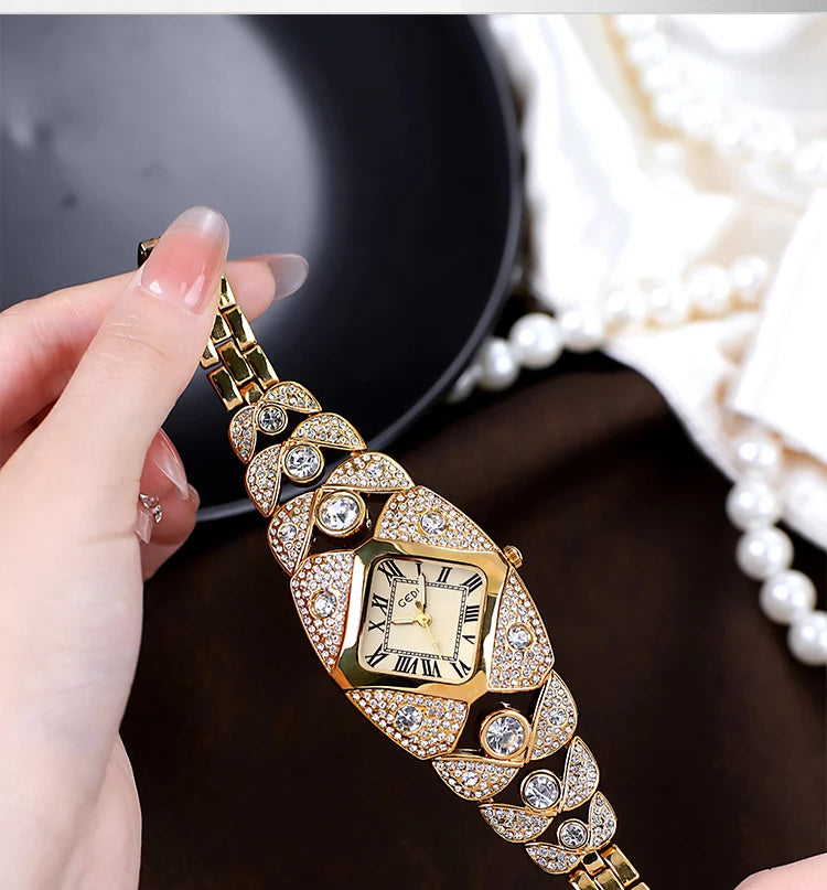 A close-up of a gold-toned quartz wristwatch featuring diamond inlay and decorative elements, held by a hand.