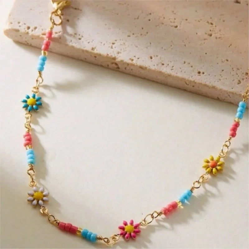 Goldene Nelkenkette als Knöchelarmband für Frauen mit farbenfrohen Blumenperlen