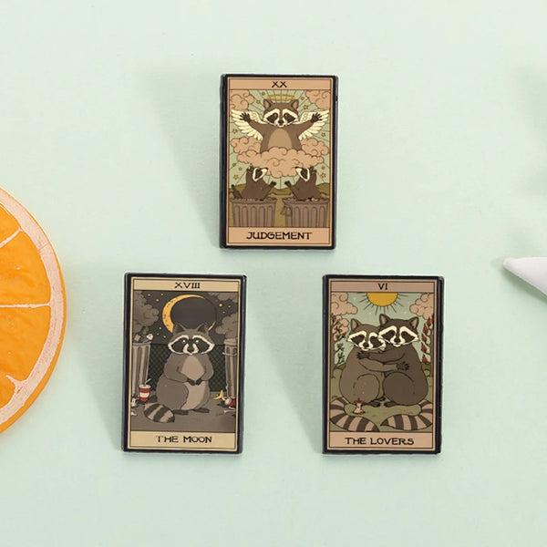 A set of three tarot card enamel pins featuring woodland animals and symbolic imagery on a light green background.