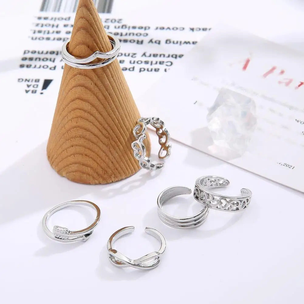 A set of adjustable open toe rings made of silver metal displayed on a white background.