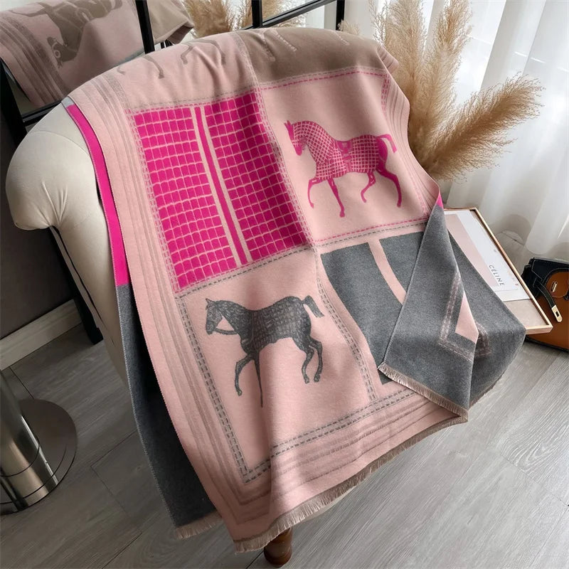 A pink and gray plaid cashmere feel scarf draped over a light-colored surface.