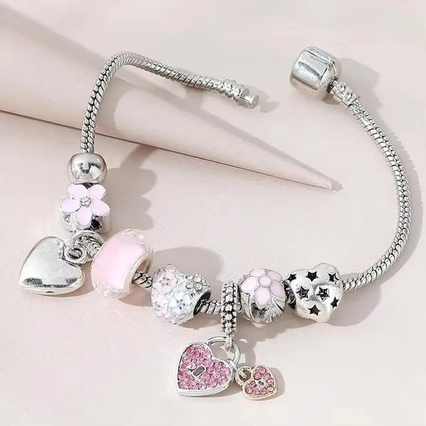 Silber- und rosa Perlenarmband-Set mit Herz- und Zierelementen.
